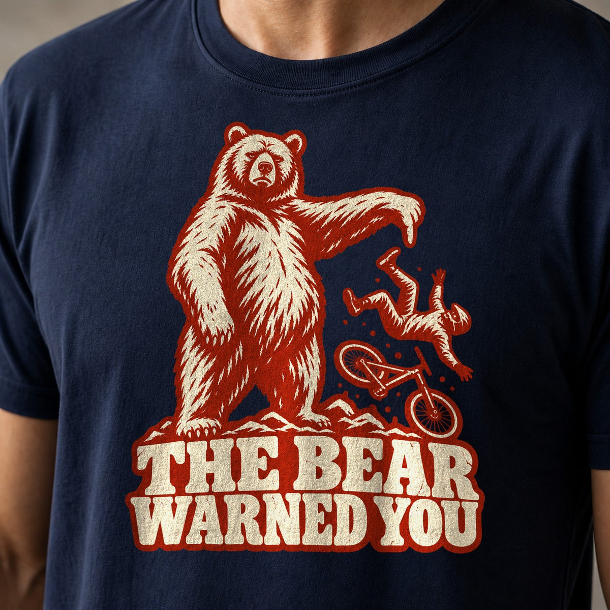 The Bear Warned You funny mountain bike t-shirt in Navy — standing bear pointing at a mountain biker going over the bars above The Bear Warned You — close-up of the print