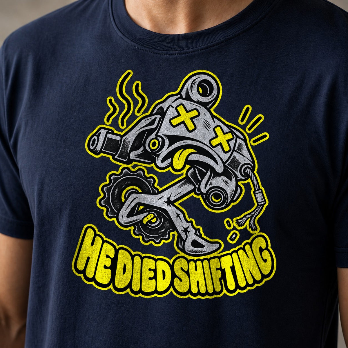He Died Shifting funny mountain bike t-shirt in Navy — cartoon rear derailleur with X eyes and snapped cable above He Died Shifting text — close-up of the print