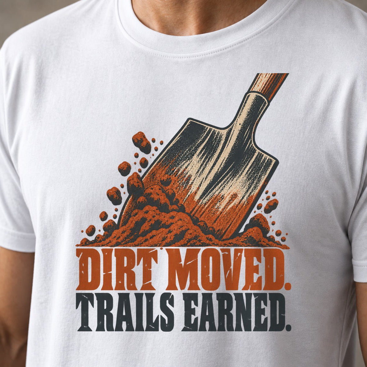 Dirt Moved. Trails Earned. funny mountain bike t-shirt in White — trail shovel driven into a pile of dirt above Dirt Moved Trails Earned — close-up of the print