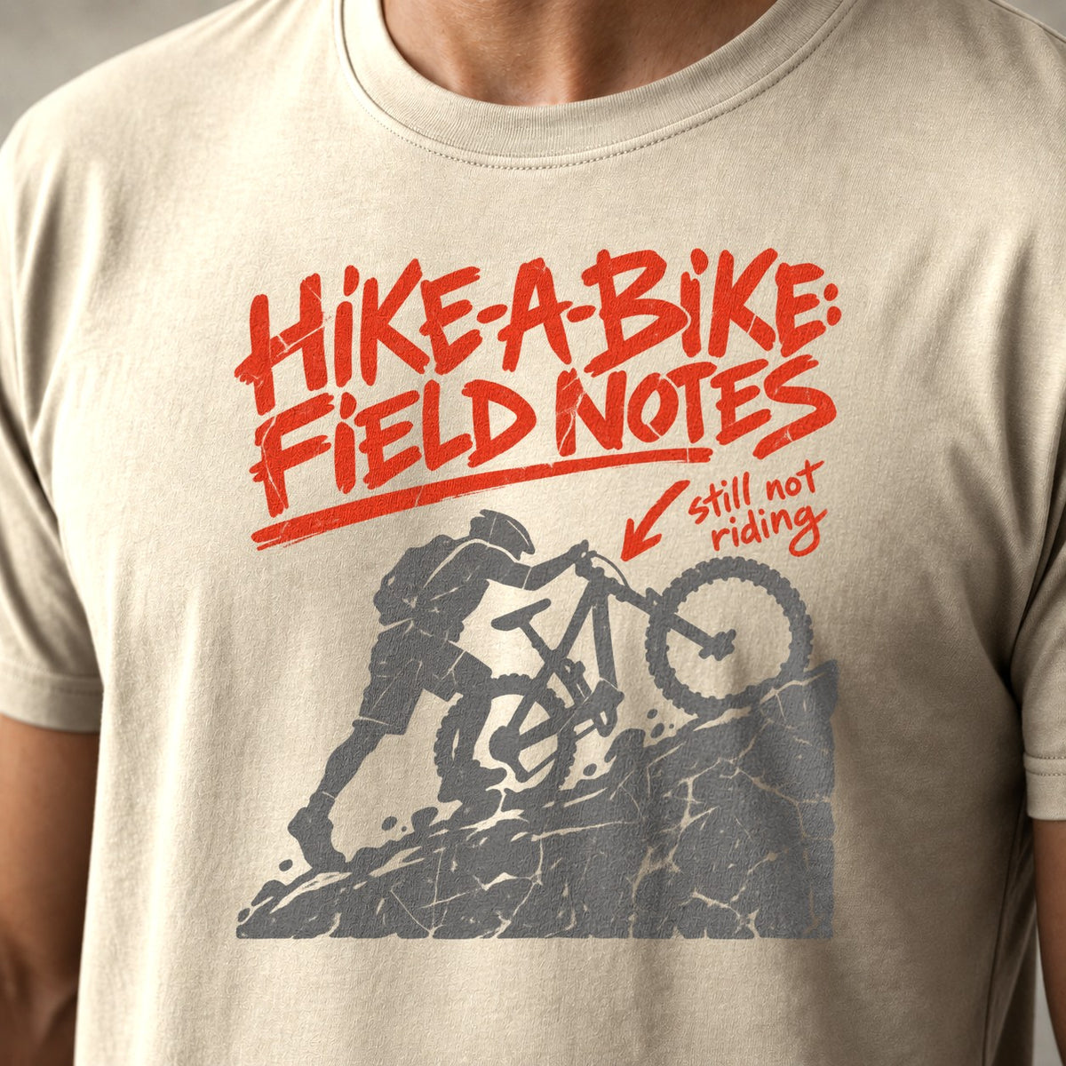 Hike-A-Bike: Field Notes mountain bike t-shirt in Natural — rider pushing up a rock face, marked in red as still not riding — close-up of the print