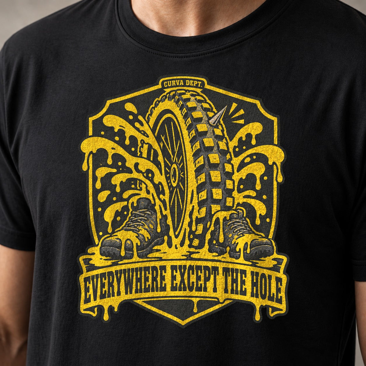 Everywhere Except The Hole mountain bike t-shirt in Black — crest of a punctured tire erupting sealant over two boots — close-up of the print