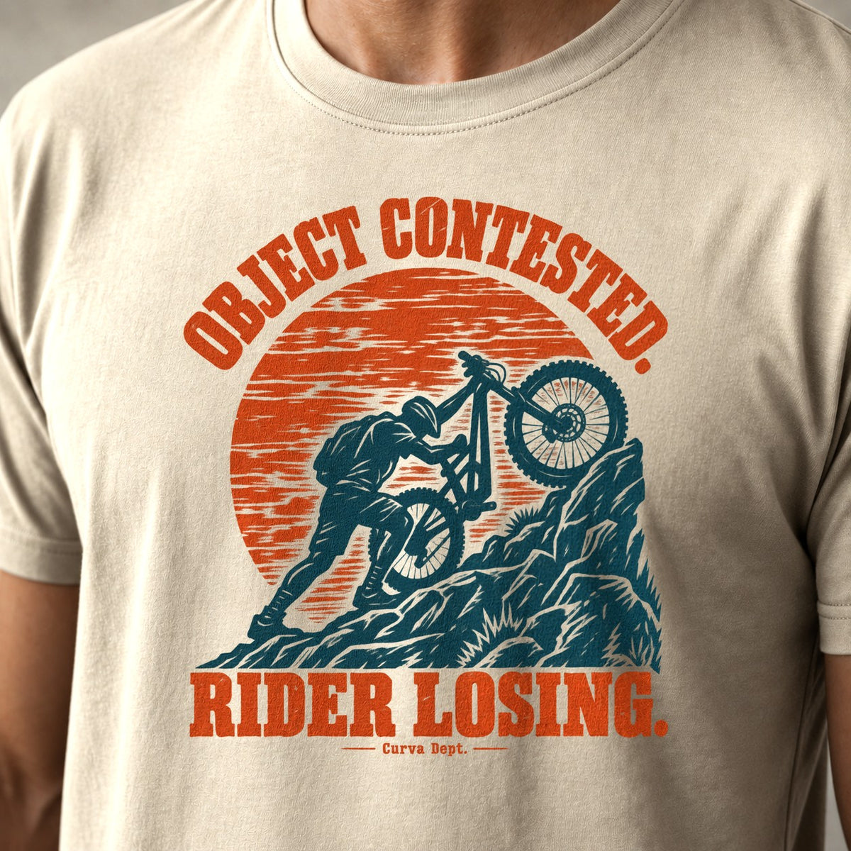Object Contested. Rider Losing. mountain bike t-shirt in Natural — woodcut rider wrestling his bike up a rock step under an orange sun — close-up of the print