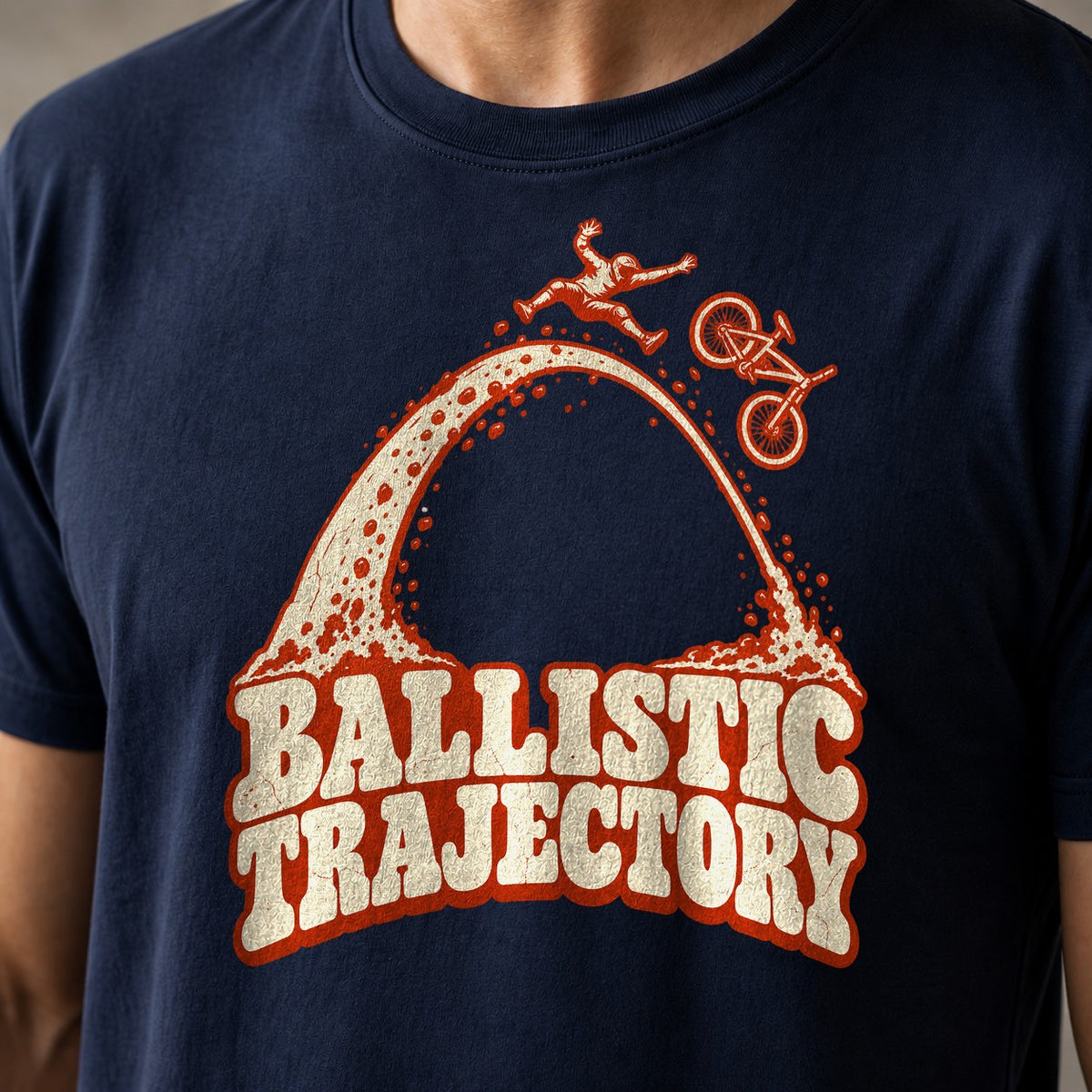 Ballistic Trajectory funny mountain bike t-shirt in Navy — rider separating from his bike at the apex of a big dirt arc above Ballistic Trajectory lettering — close-up of the print