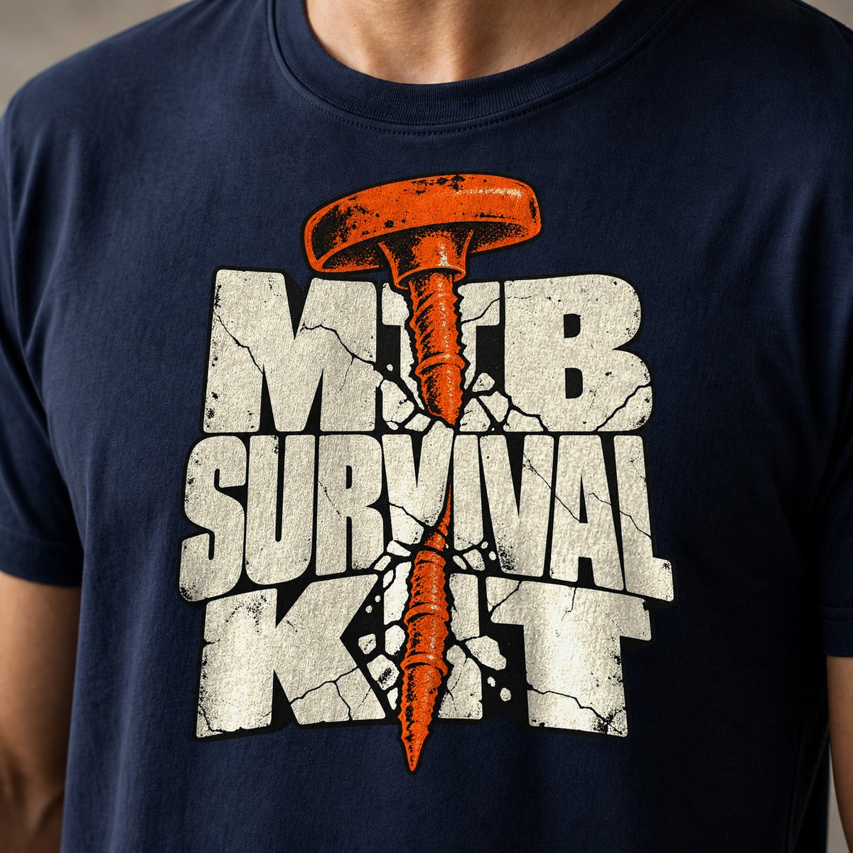 MTB Survival Kit funny mountain bike t-shirt in Navy — orange tubeless tire plug driven through cracked MTB Survival Kit letters — close-up of the print