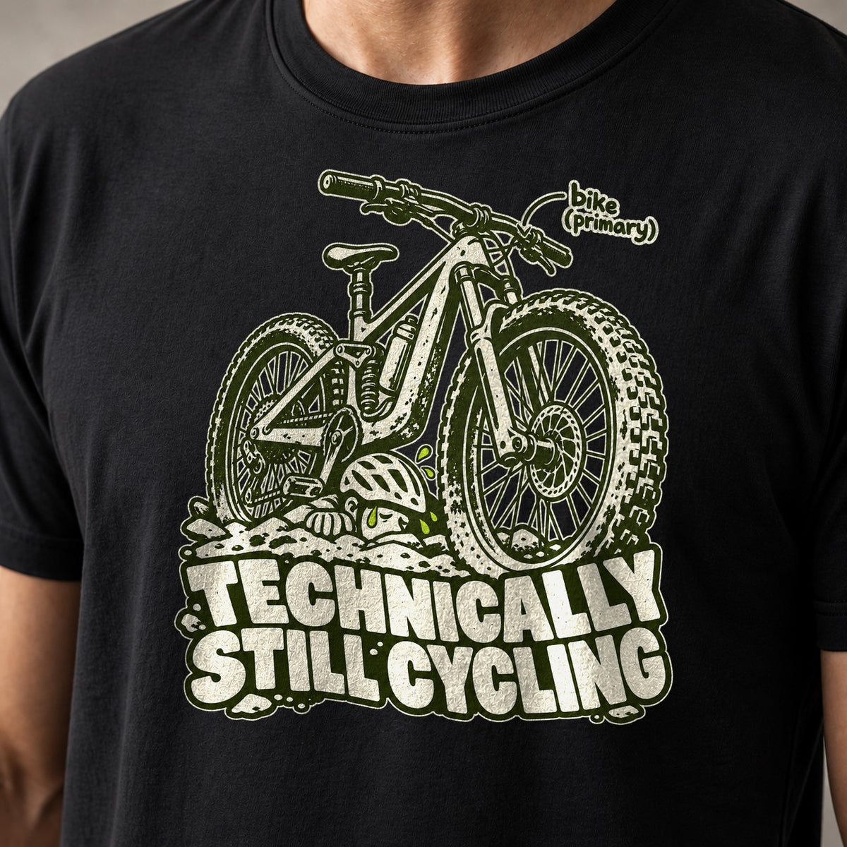 Technically Still Cycling funny mountain bike t-shirt in Black — chunky fat-tire trail bike on a pile of rocks — close-up of the print