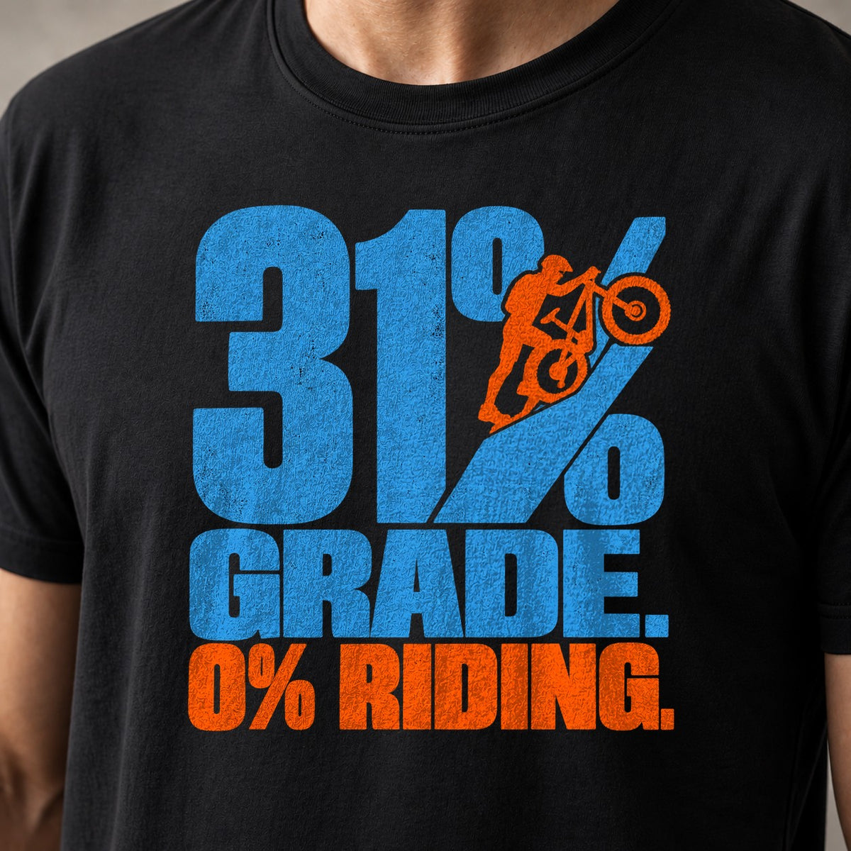 31% Grade. 0% Riding. mountain bike t-shirt in Black — tiny rider pushing his bike up the slash of a giant percent sign — close-up of the print