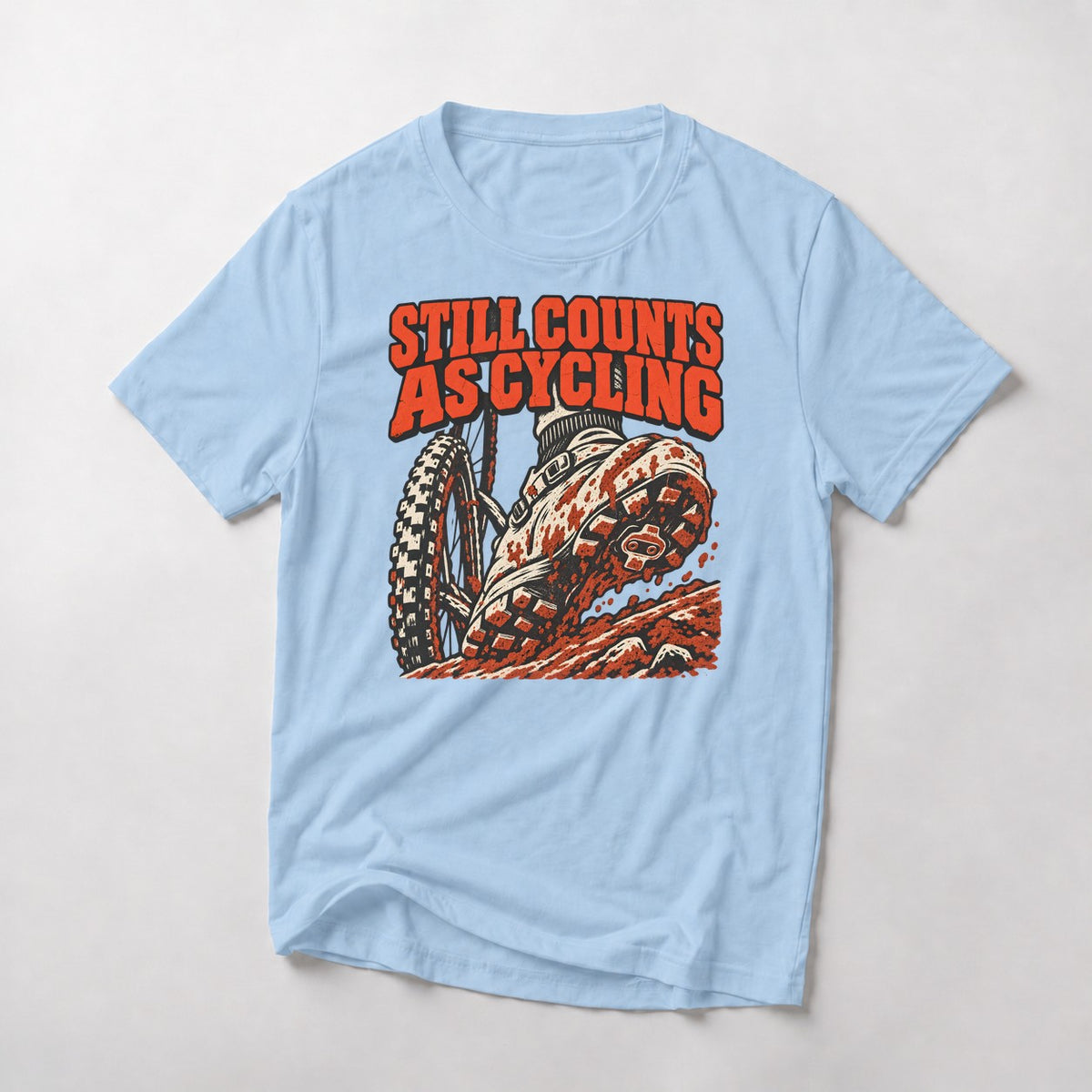 Still Counts As Cycling mountain bike t-shirt in Light Blue — mud-caked shoe planted on a rocky step beside the front wheel