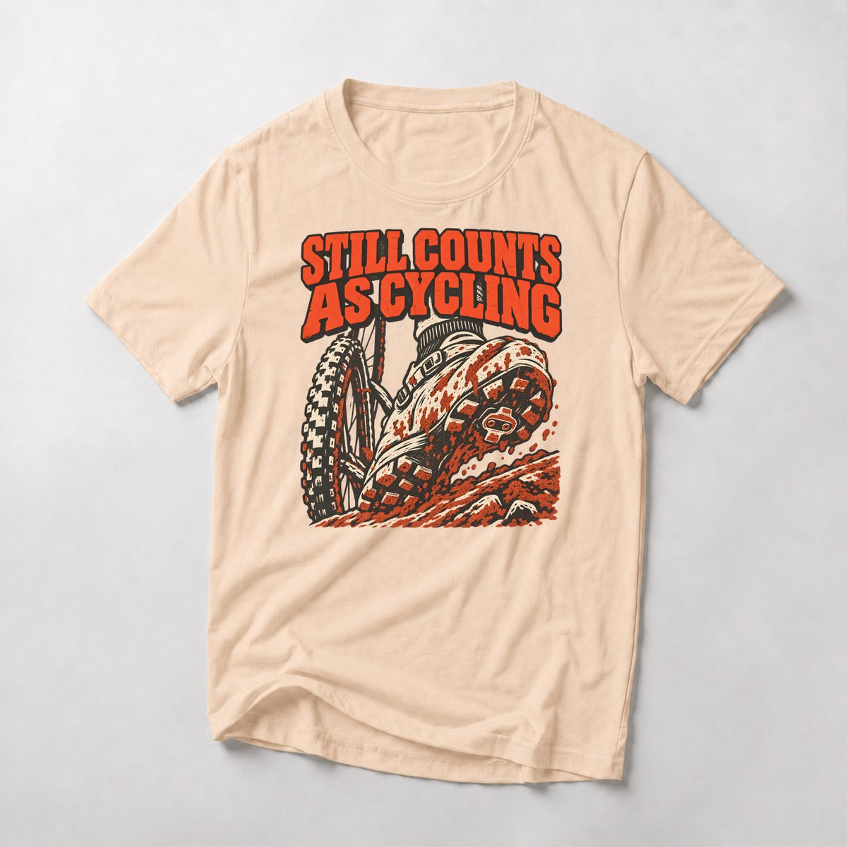 Still Counts As Cycling mountain bike t-shirt in Natural — mud-caked shoe planted on a rocky step beside the front wheel