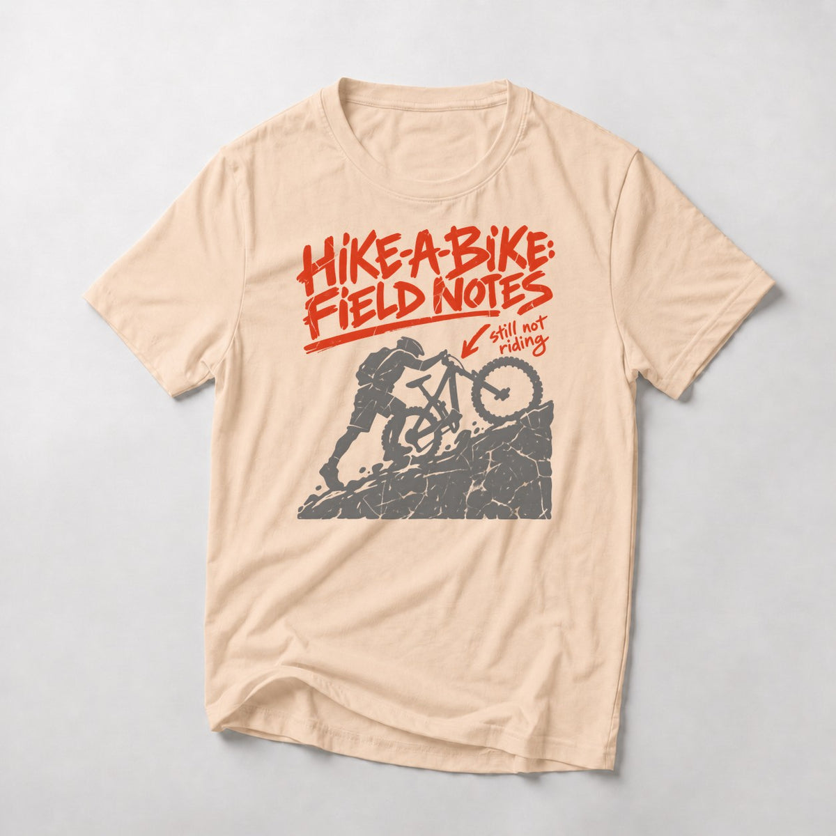Hike-A-Bike: Field Notes mountain bike t-shirt in Natural — rider pushing up a rock face, marked in red as still not riding