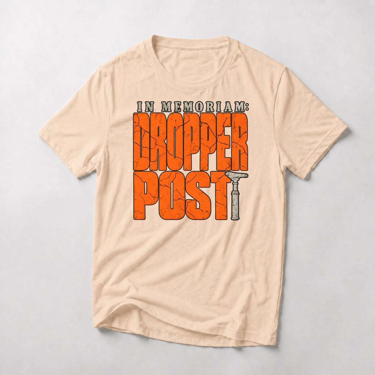 In Memoriam: Dropper Post mountain bike t-shirt in Natural — cracked orange letters with a worn dropper post as the T