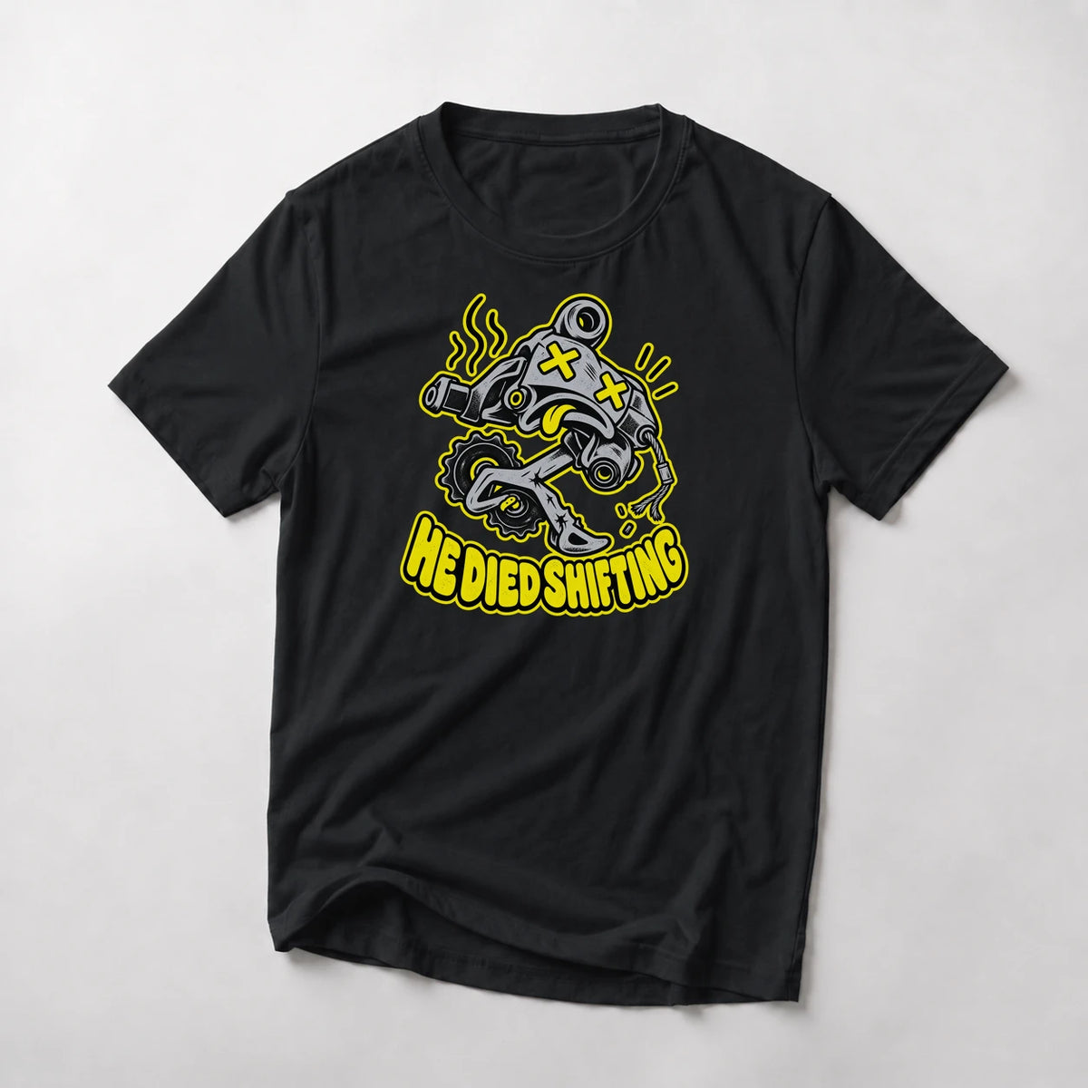 He Died Shifting funny mountain bike t-shirt in Black — cartoon rear derailleur with X eyes and snapped cable above He Died Shifting text