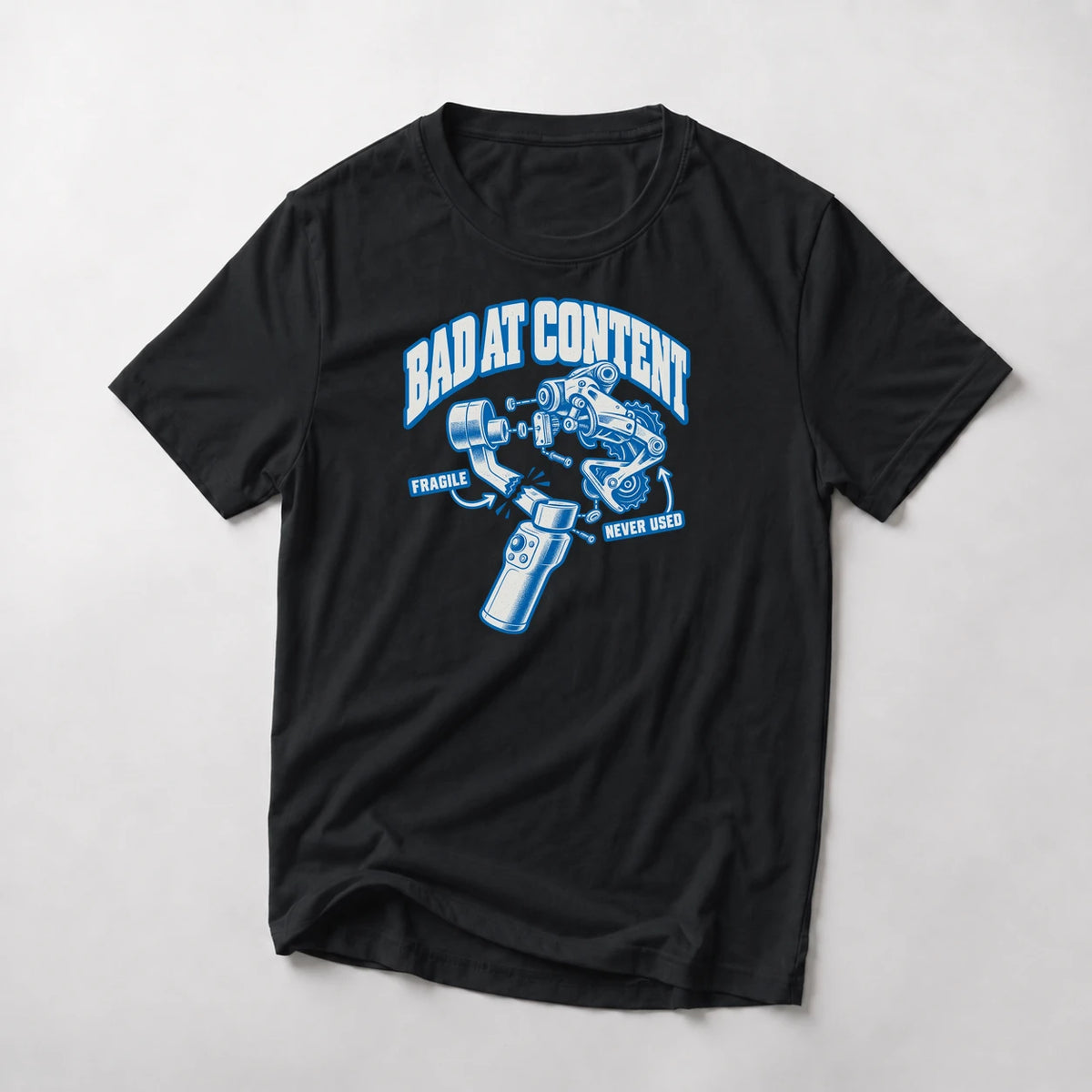 Bad At Content funny mountain bike t-shirt in Black — exploded diagram of a phone gimbal and rear derailleur labeled Fragile and Never Used under Bad At Content