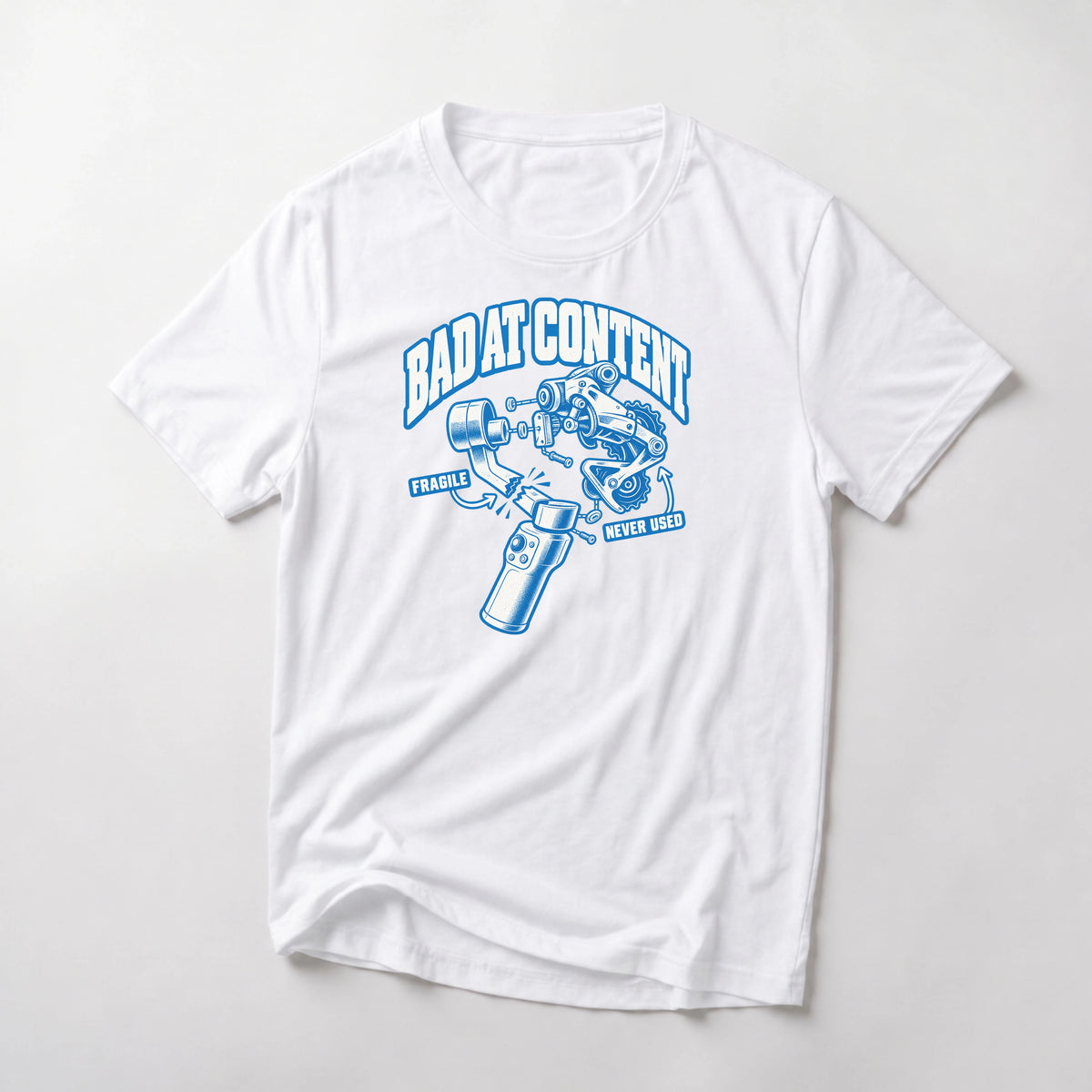 Bad At Content funny mountain bike t-shirt in White — exploded diagram of a phone gimbal and rear derailleur labeled Fragile and Never Used under Bad At Content