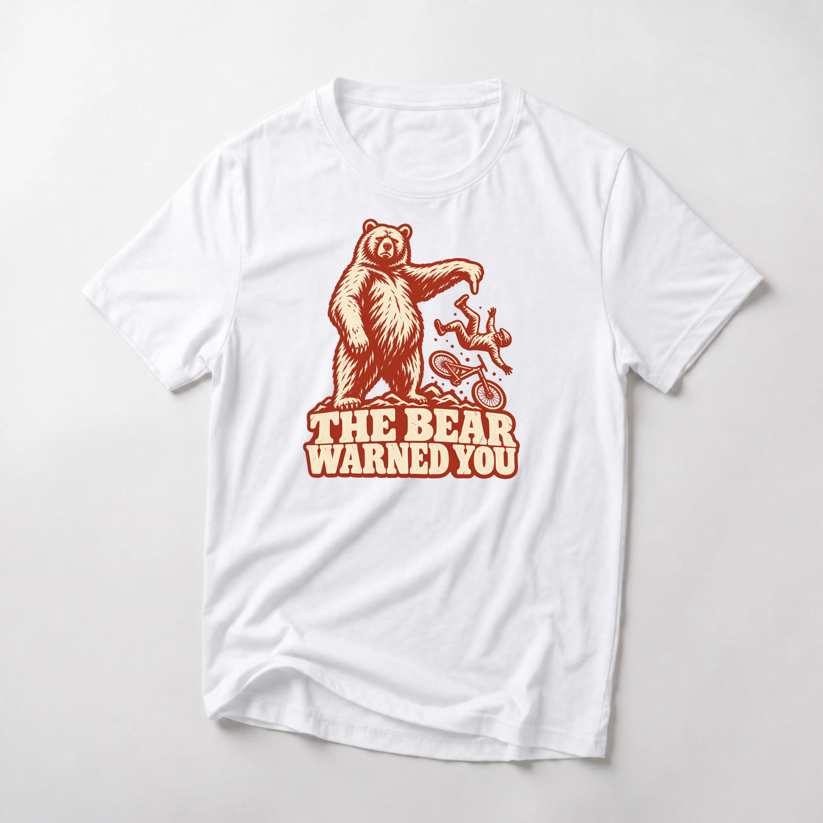 The Bear Warned You funny mountain bike t-shirt in White — standing bear pointing at a mountain biker going over the bars above The Bear Warned You