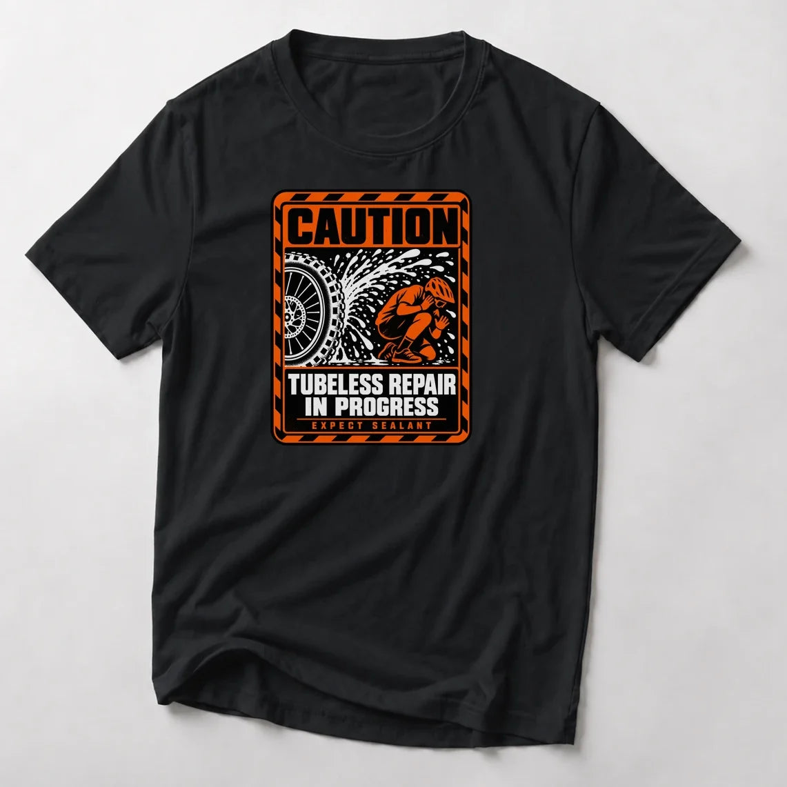 Caution Tubeless Repair In Progress funny mountain bike t-shirt in Black — orange hazard sign with a tire spraying sealant at a crouching rider