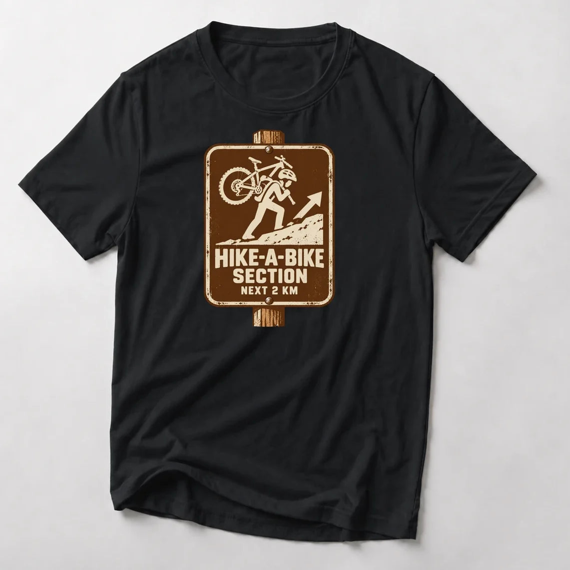 Hike-A-Bike Section Next 2 KM mountain bike t-shirt in Black — brown park-style trail sign of a rider carrying a bike uphill